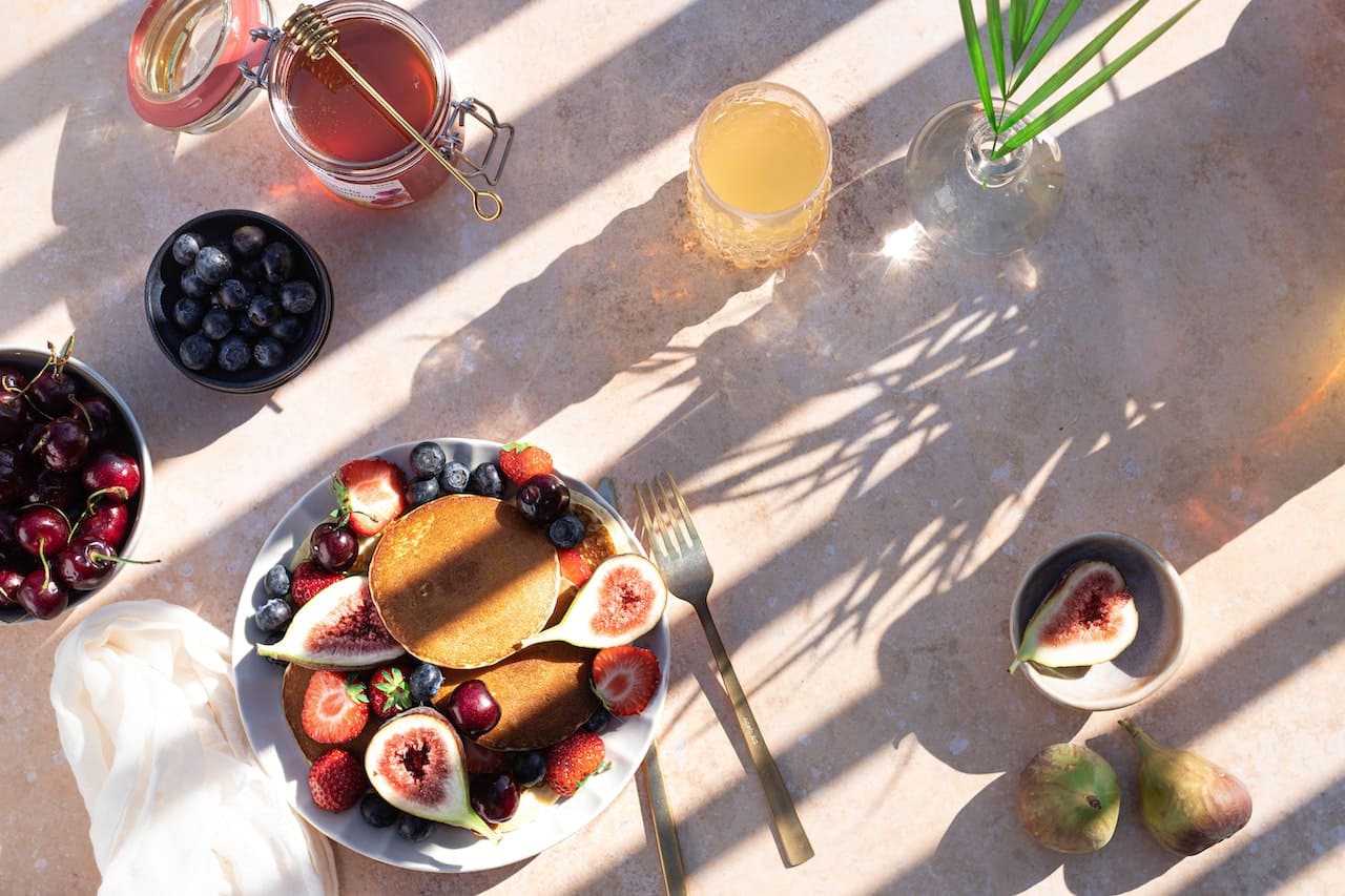 A healthy breakfast spread that includes blueberries, strawberries, figs, cherries and more.