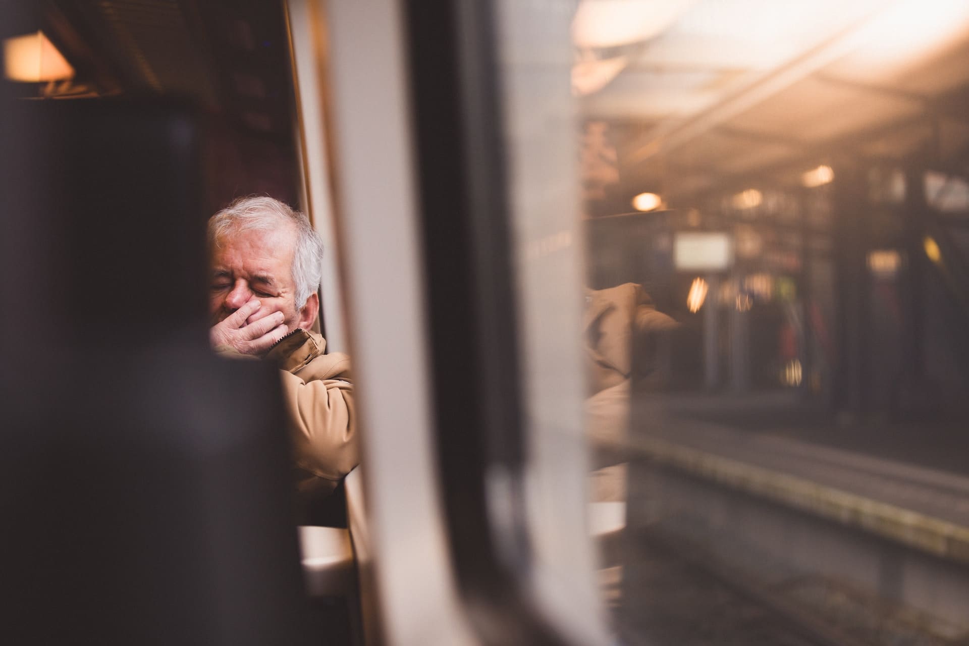 Older man sat on a train struggling with how to deal with fatigue