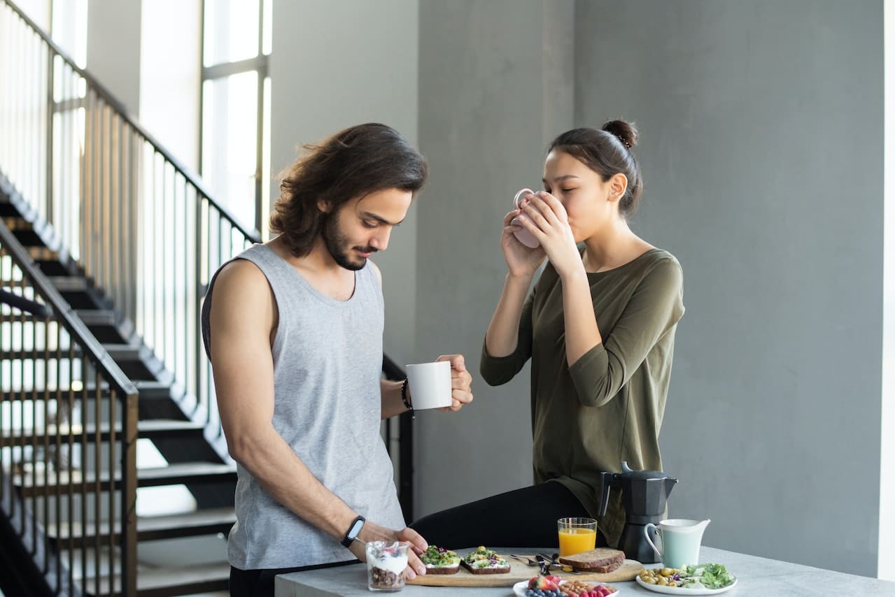 A man and woman eating a breakfast containing both prebiotics and probiotics after reading a guide on prebiotic vs probiotic