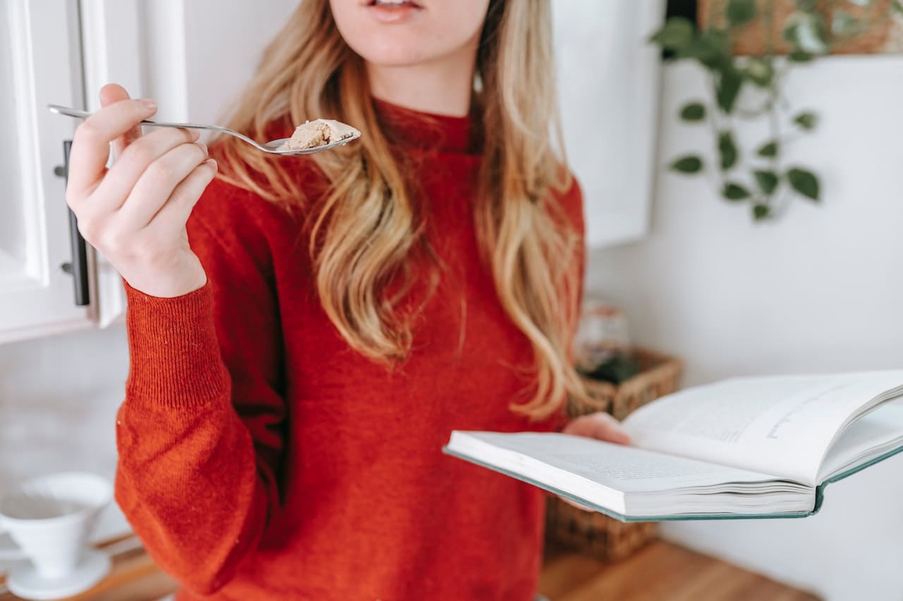 A woman eating yogurt at home after reading about probiotic benefits