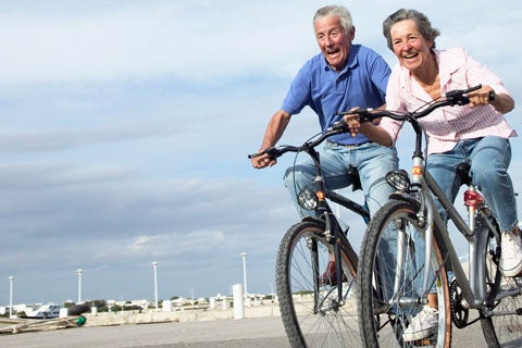 Senior couple riding bicycles together outdoors